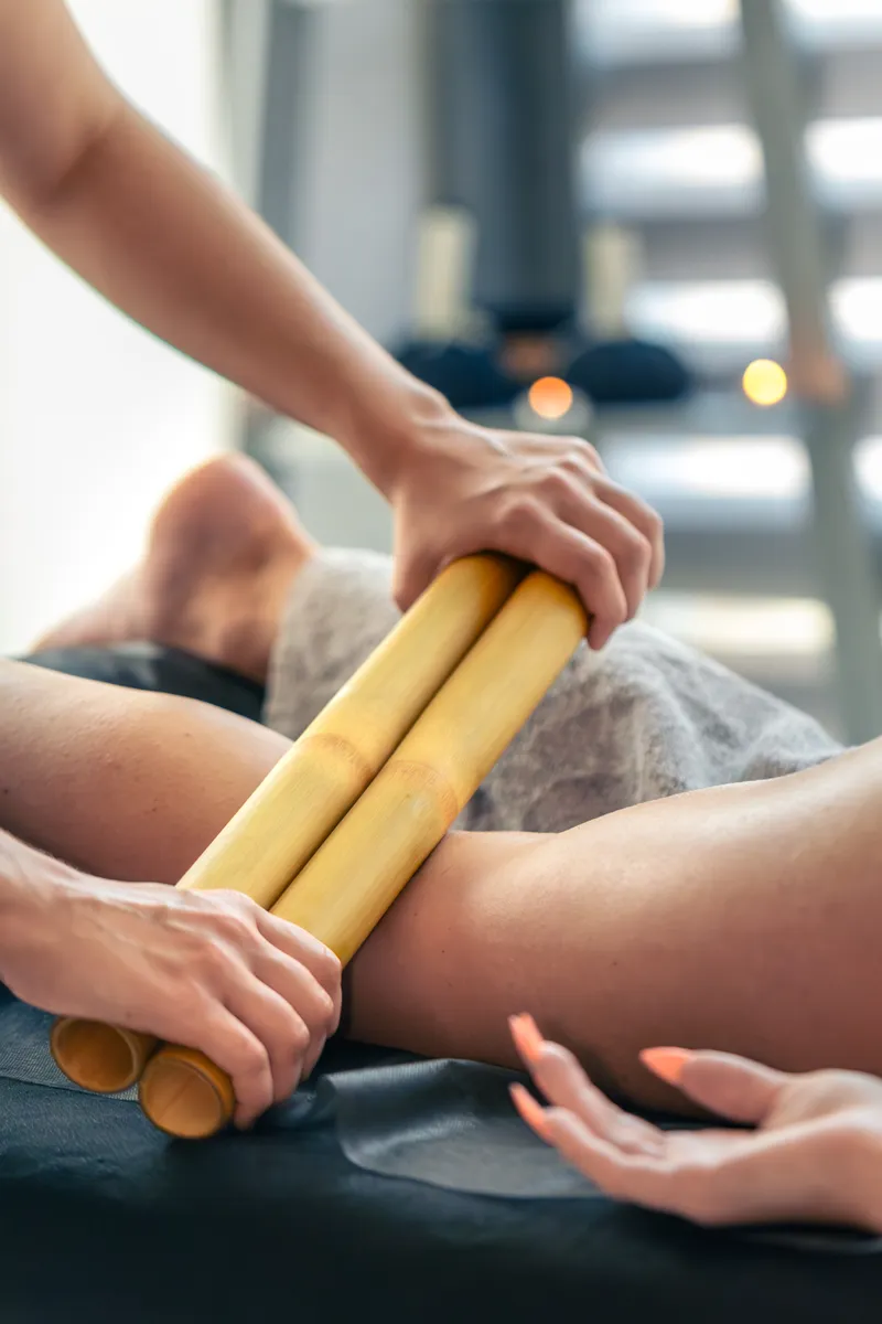 Bambuterapia sendo aplicada nas coxas para contorno e modelagem em Curitiba.